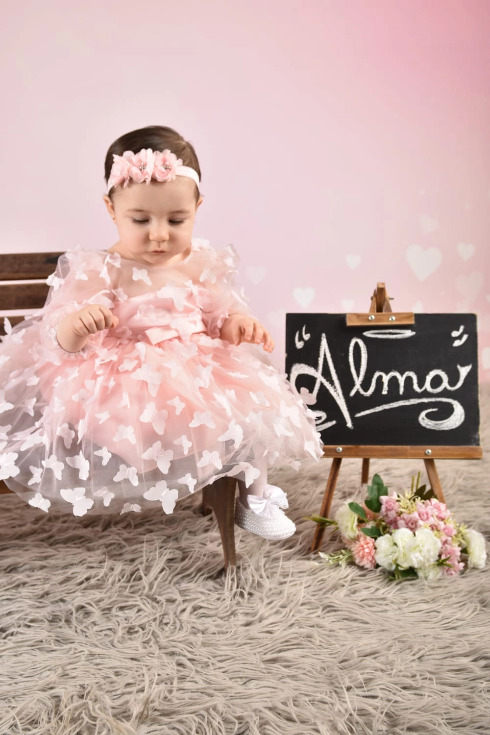 Beba con vestido rosa con aplicaciones de mariposas