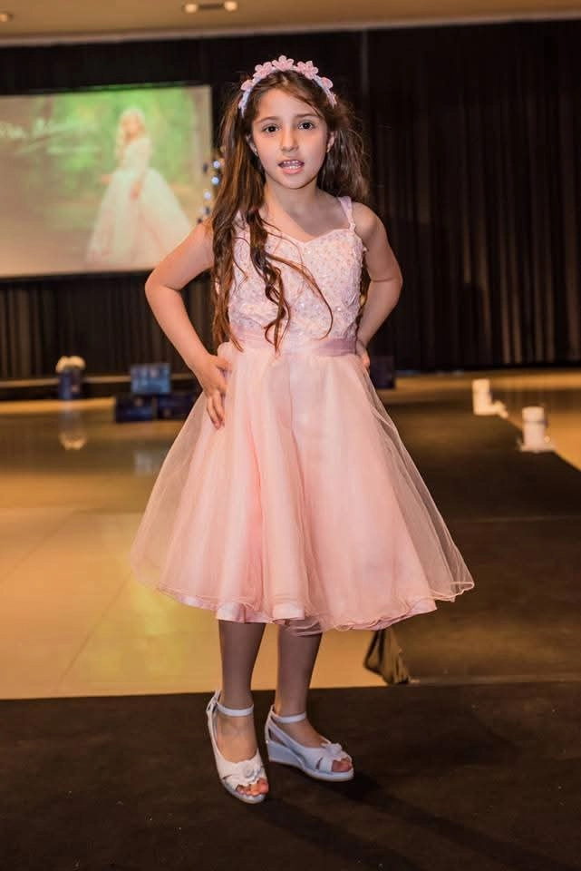 Niña con vestido rosa de fiesta sobre pasarela