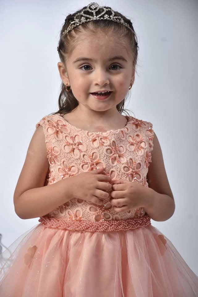Niña con vestido lila corto de fiesta sobre pasarela